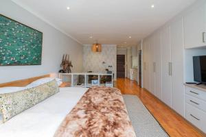 a living room with a bed and a television at Modern apartment in culturally vibrant Melville 22 in Johannesburg