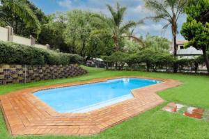 a swimming pool in the yard of a house at Modern apartment in culturally vibrant Melville 22 in Johannesburg