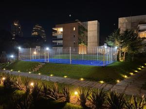 Apartamento a estrenar en complejo Mansa inn2 في بونتا دل إستي: ملعب كرة سلة أمام مبنى في الليل