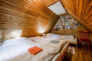 1 dormitorio con 2 camas en una habitación de madera en Old Fashioned Cottage in Lopusna dolina near High Tatras en Lučivná