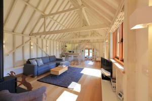 ein Wohnzimmer mit einem blauen Sofa und einem Tisch in der Unterkunft The Cowshed, Tunbridge Wells in Royal Tunbridge Wells