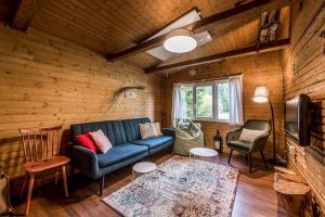 sala de estar con sofá azul y sillas en Old Fashioned Cottage in Lopusna dolina near High Tatras en Lučivná