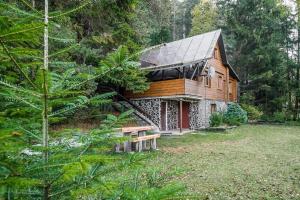 Old Fashioned Cottage in Lopusna dolina near High Tatras في Lučivná: منزل خشبي أمامه مقعد