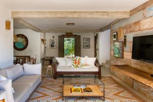 ein Wohnzimmer mit einem Sofa und einem Tisch in der Unterkunft Casa Laranjeiras, Rio da Barra beach, Trancoso in Trancoso