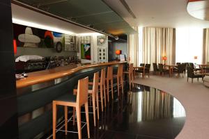 a restaurant with a bar with chairs and tables at Hotel Santa Maria in Fátima