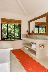 ein Bad mit einem Waschbecken und einem Spiegel in der Unterkunft Casa Laranjeiras, Rio da Barra beach, Trancoso in Trancoso