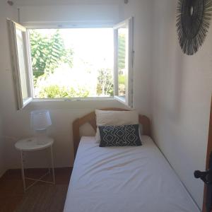 a small bedroom with a bed with a window at Casa Elisa 3 bedrooms 2 bathrooms 4 airco's shared pool in Alcossebre