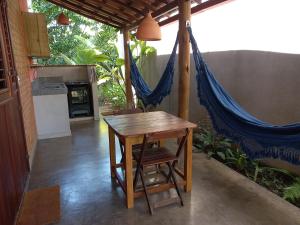 a table and chairs and a hammock in a room at Vila Prosperidade Trancoso in Trancoso