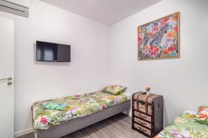Habitación con 2 camas y TV en la pared. en Magic Badalona Apartment, en Badalona