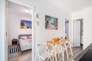 una habitación con mesa y sillas y un dormitorio en Magic Badalona Apartment, en Badalona