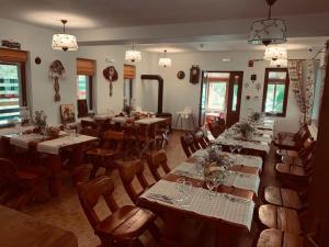 a restaurant with long tables and chairs and lights at Dorul Pescarului in Curtea de Argeş