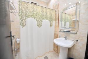 a bathroom with a shower curtain and a sink at Aseel Alsharq Hotel in Riyadh