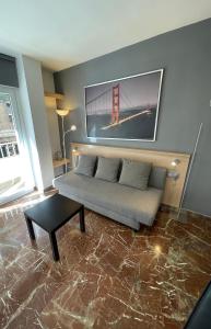 a living room with a couch and a picture of the golden gate bridge at CONSTITUCIÓN SUITE CONFORT I in Granada