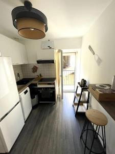 uma cozinha com um lavatório e um fogão forno superior em Appartement Centrale Confort em Montalieu-Vercieu