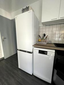 Montalieu-VercieuにあるAppartement Centrale Confortのキッチン(白い冷蔵庫、コンロ付)