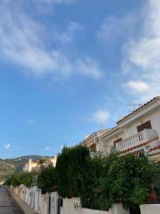 a row of white buildings with plants on a street at Casa Elisa 3 bedrooms 2 bathrooms 4 airco's shared pool in Alcossebre