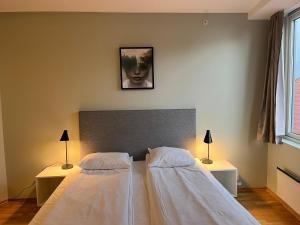 a bedroom with a white bed and white walls at City Hostel Bergen in Bergen