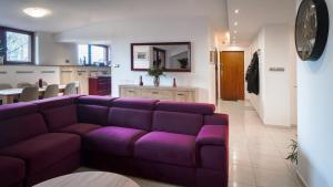 a living room with a purple couch and a kitchen at Apartament Wschodnia in Lublin