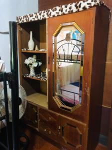 a wooden cabinet with a mirror in a room at Hub Backpackers Hangout in Coron