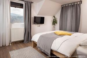 una camera con letto, TV e finestra di Casa269b - Cozy house with scandinavian design a Moieciu de Jos