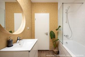een badkamer met een wastafel, een douche en een spiegel bij Casa269b - Cozy house with scandinavian design in Moieciu de Jos