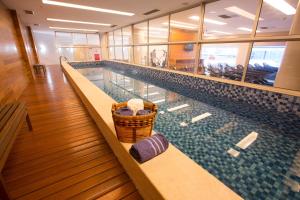 a swimming pool with a wicker basket sitting on a bench at Fusion Hplus Express + in Brasília