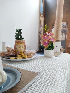 una mesa con un plato de comida y flores en ella en Figli Di Agata, en Catania