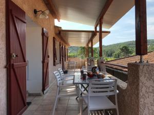 una mesa y sillas en un balcón con vistas en A Rossa Location, en Favone