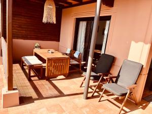 a room with a wooden table and two chairs at Stillvolle Villa mit Terrasse, Garten und Grill in Lajares