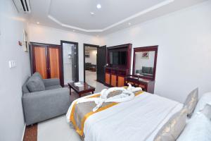 1 dormitorio con cama, sofá y TV en Aseel Alsharq Hotel en Riad