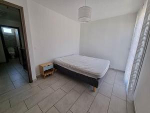 een slaapkamer met een bed en een tegelvloer bij Maison - proche centre ville in Céret