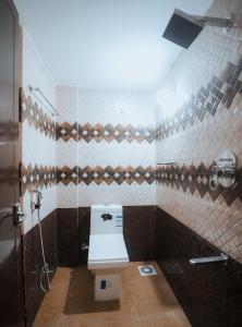 a bathroom with a toilet and a shower in it at BEVERLY SUITES in Wayanad