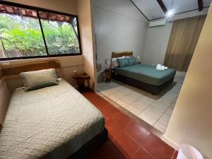 1 dormitorio con 2 camas y ventana en Casa Tropical Playa Grande en Cuajiniquil
