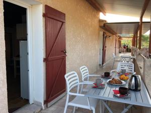 - une table et des chaises sur la terrasse couverte d'une maison dans l'établissement A Rossa Location, à Favone