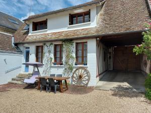 uma mesa e cadeiras em frente a uma casa em Chez Robins em Trie-Château