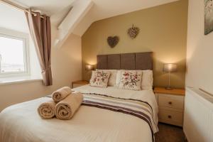 een slaapkamer met een bed met handdoeken erop bij Bennar Isa Cottages Dyffryn Ardudwy in Barmouth