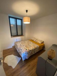 a small bedroom with a bed and a window at Appartement centre-ville de Valognes in Valognes