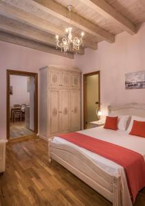 een slaapkamer met een groot bed en een kroonluchter bij Palazzo di Irene in Chania