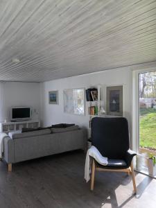 a living room with a couch and a chair at Ferienhaus am Vänern mit Seeblick in Mariestad