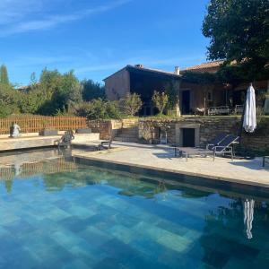 una piscina in un cortile con una casa di Hestia a Robion en Luberon