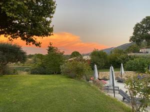 eine Liegewiese mit Stühlen und Sonnenschirmen im Garten in der Unterkunft Hestia in Robion en Luberon