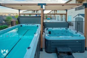 bañera de hidromasaje en un patio con sombrilla en Zion Village Earth & Fire, Private Swim Spa and Hot Tub, en Hurricane