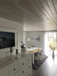 a kitchen with a table and a dining room with a table and chairs at Ferienhaus am Vänern mit Seeblick in Mariestad