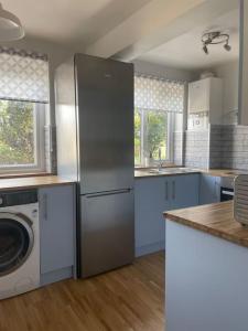 a kitchen with a refrigerator and a washing machine at Stylish & Spacious 2 Storey, 3 Bed Apartment in Kent