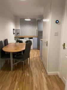 ein Esszimmer mit einem Holztisch und Stühlen in der Unterkunft Stylish & Spacious 2 Storey, 3 Bed Apartment in Kent