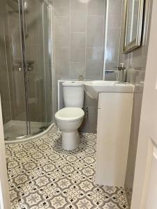 ein Bad mit einem WC, einem Waschbecken und einer Dusche in der Unterkunft Stylish & Spacious 2 Storey, 3 Bed Apartment in Kent