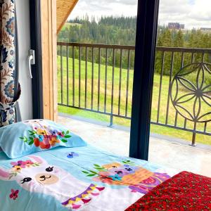 a bed with pillows on it next to a window at Domek Tatry - Stacja Wierchowa 972 m in Brzegi