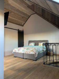 una camera con un letto in una stanza con soffitto in legno di Vélo 94 bij Soof a Geel