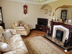 a living room with a fireplace and a mirror at Hillview House in Bellaghy