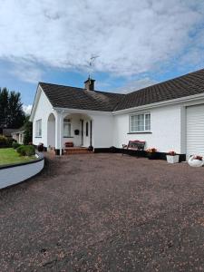 a white house with a gravel driveway in front of it at Hillview House in Bellaghy